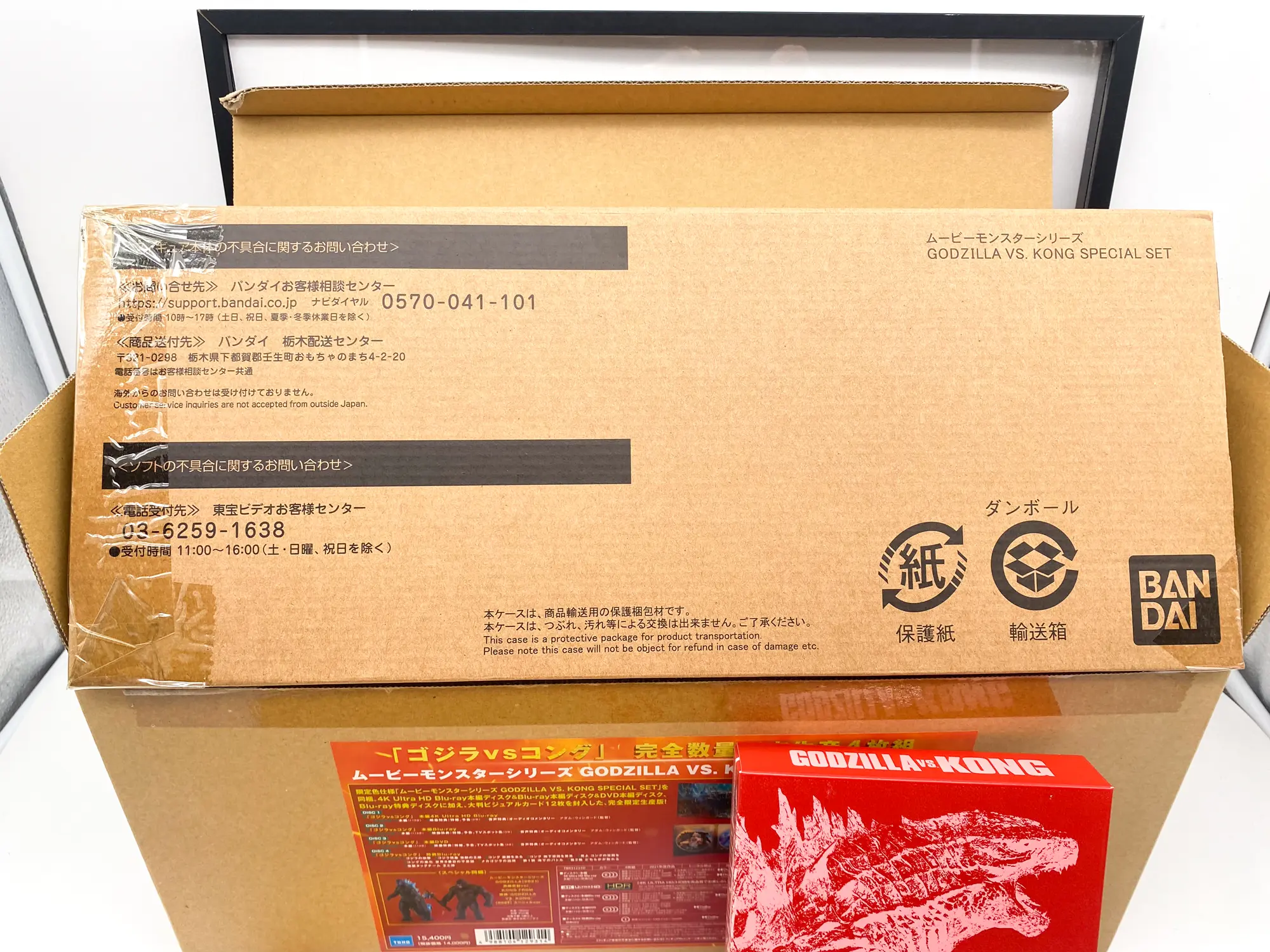 Coffret Godzilla vs Kong ouvert avec carton de protection Bandai et étui rouge