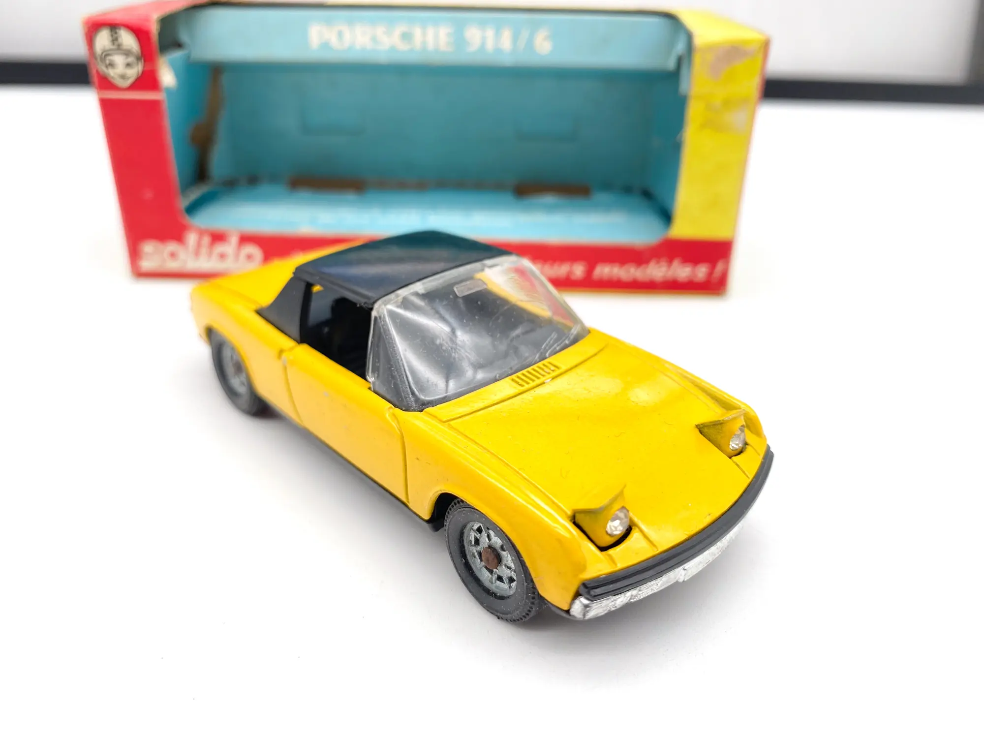 Porsche 914/6 Solido jaune vue de trois quarts avant devant sa boîte