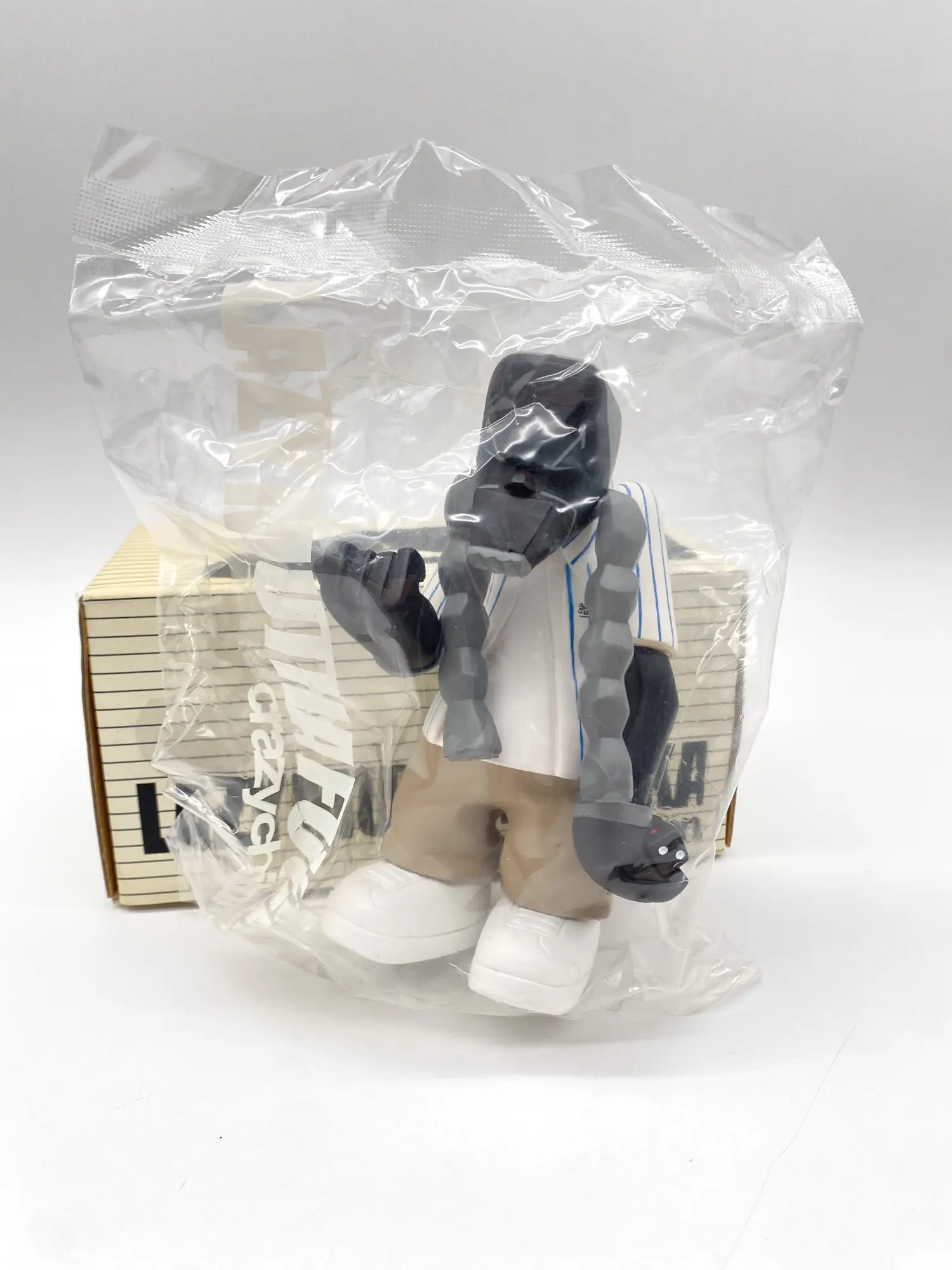 Figurine Michael Lau MC Yan White dans son sachet transparent devant sa boîte