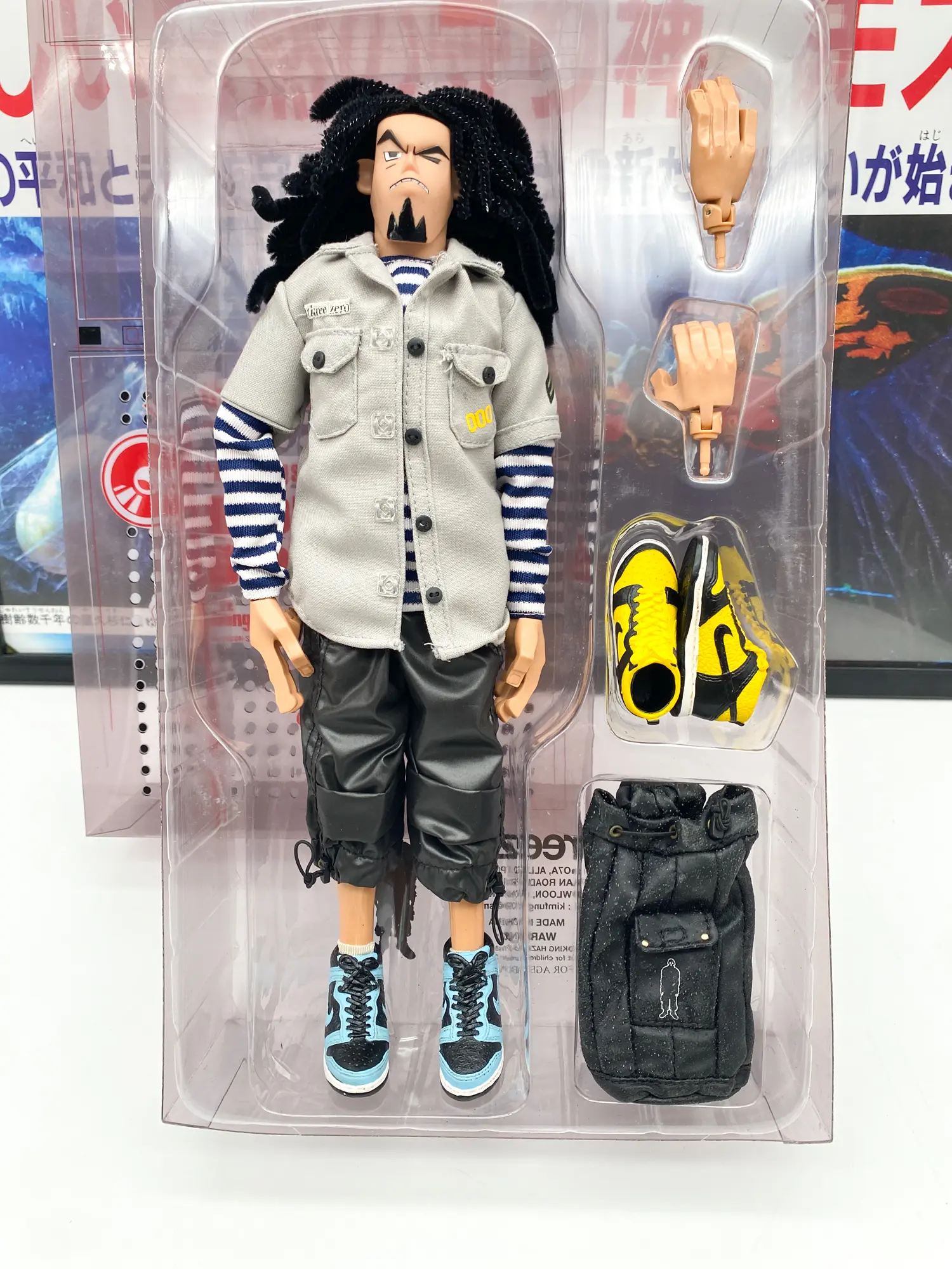 Figurine Giger dans son blister avec sneakers jaunes, sac et mains interchangeables