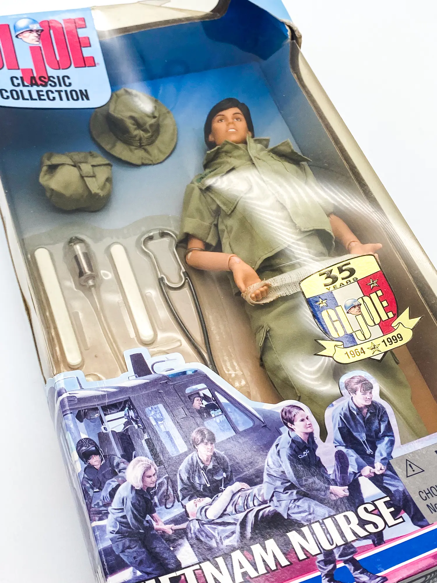 Vue inclinée de la figurine Vietnam Nurse et de ses accessoires en boîte